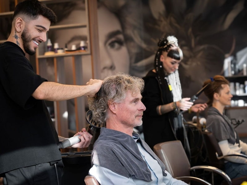 KLIPP Stylisten Stylist föhnt die Haare eines Kunden