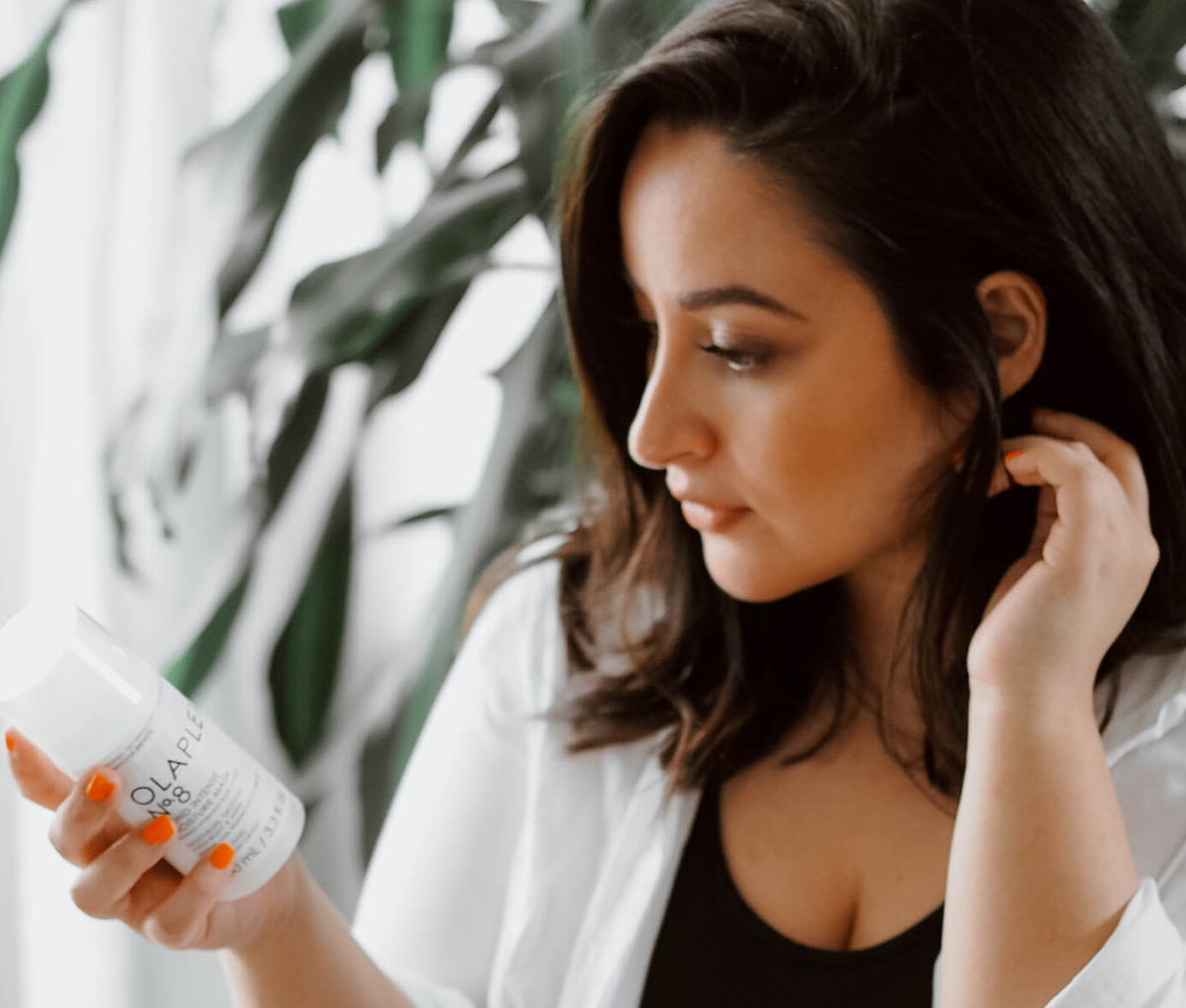 Frau-die-sich-interessiert-ein-Olaplex-Produkt-anschaut Frau-die-sich-interessiert-ein-Olaplex-Produkt-anschaut